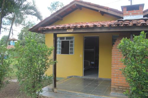 a small yellow house with a door at Pousada e Camping Carrion in Itu