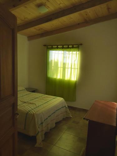 a bedroom with a bed and a green window at Cabaña en Ituzaingo in Ituzaingó