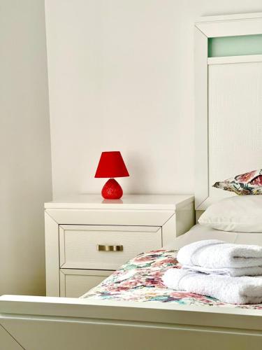 a bedroom with a bed with a red lamp on it at Agropa Rooms & Garden Events in Bistriţa
