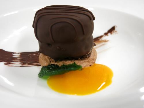 a chocolate dessert on a white plate with an egg at Berg-Spa & Hotel Zamangspitze in Sankt Gallenkirch