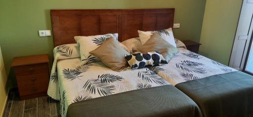a bed with pillows on it in a bedroom at El Rato Apartamentos Rurales in Navia