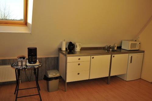 eine Küche mit einer Spüle und einer Mikrowelle in der Unterkunft Witte Weelde Texel in De Koog