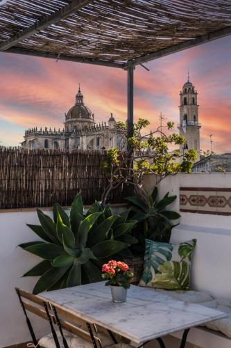 a table on a balcony with a building in the background at La Gitanilla Alojamiento & Encanto Jerez in Jerez de la Frontera