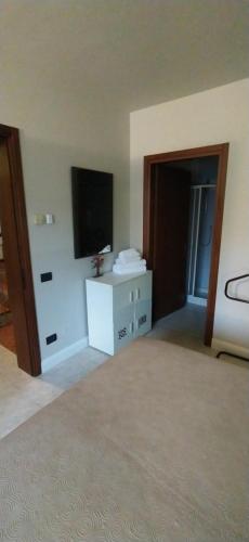een woonkamer met een televisie en een witte dressoir bij Hotel Milano San Giovanni Lupatoto in San Giovanni Lupatoto