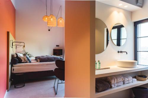 een badkamer met een bed, een wastafel en een spiegel bij KOOON in Staden