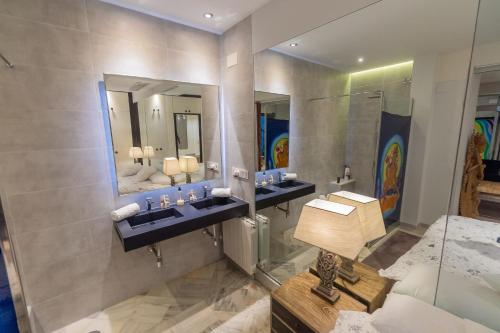 uma casa de banho com dois lavatórios e dois espelhos em Suite Bali em Sevilha