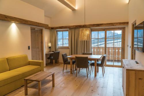 Una sala de estar con un sofá, una mesa y sillas. en Huber unterm Baum, en Lagundo