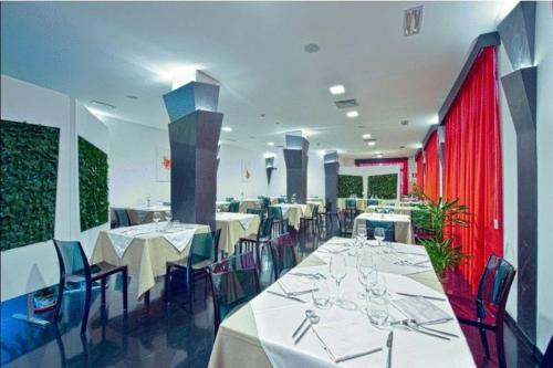 a dining room with white tables and blue chairs at Eden Hotel in San Salvo