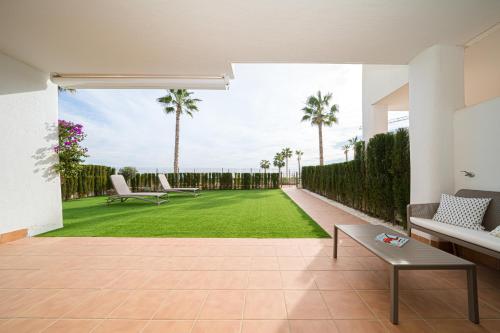 a living room with a lawn and palm trees at Linara in San Juan de los Terreros