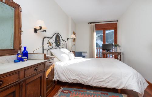 a bedroom with a bed and a dresser and a window at Apartament Terrasses F in El Tarter