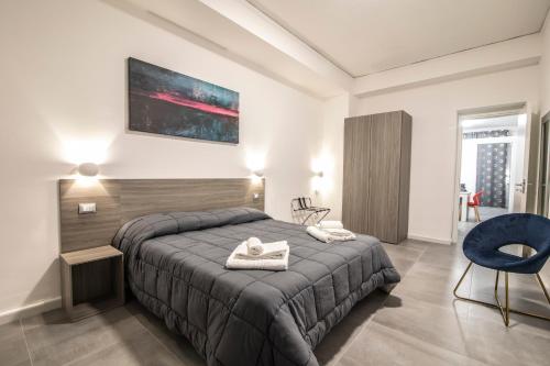 una camera con un grande letto e una sedia blu di Piano Monaco Apartment a Carini