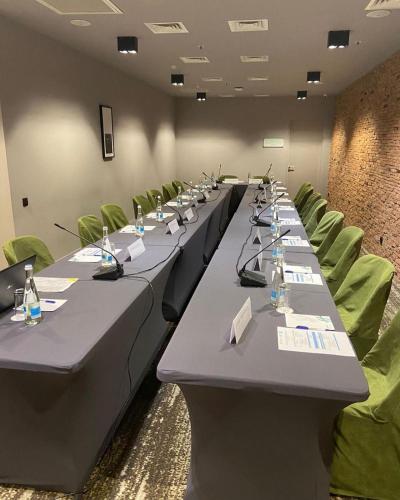 a conference room with long tables and green chairs at Holiday Inn Telavi by IHG in Tʼelavi