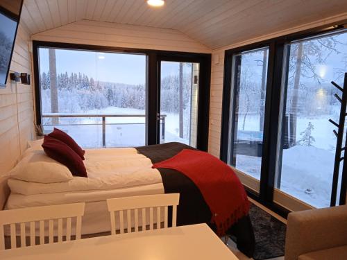 a bedroom with two beds and a large window at Lake Resort Paljakka in Kotila