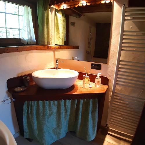 a bathroom with a bowl sink on a wooden counter at CleMaison Antica Dimora Apartments CIR VDA GIGNOD 0013 in Gignod
