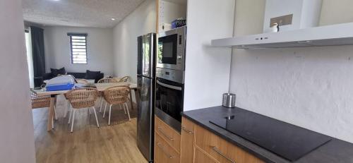 a kitchen with a black refrigerator and a dining table at Amy's appartment Coastal road Peyrebere in Pereybere