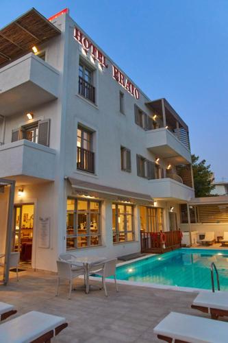 a hotel with a swimming pool in front of a building at Erato Hotel in Agia Marina Aegina