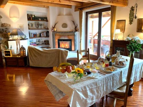 a table with fruit on it in a living room with a fireplace at Maso Azzurro Chalet in Stenico