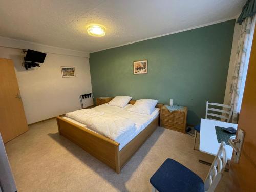 a bedroom with a bed and a green wall at Ferien- & Monteurzimmer Markhausen in Friesoythe