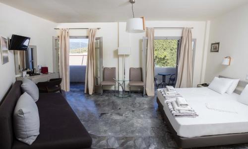 a bedroom with a large bed and a living room at Erato Hotel in Agia Marina Aegina