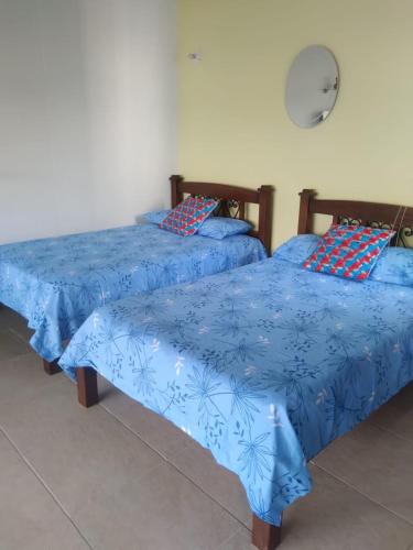 two beds sitting next to each other in a room at Apartasol Santa Fe Oficial in Santa Fe de Antioquia