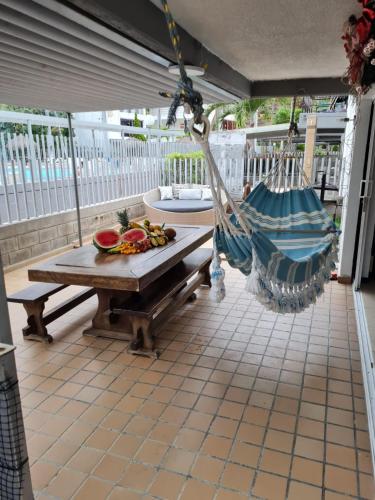 a porch with a hammock and a table and chairs at Apartasol Santa Fe Oficial in Santa Fe de Antioquia