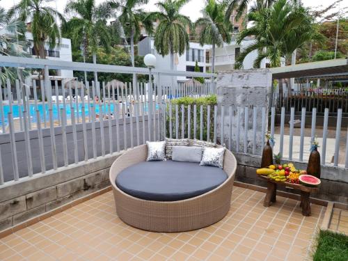 a wicker chair sitting on a patio next to a table at Apartasol Santa Fe Oficial in Santa Fe de Antioquia