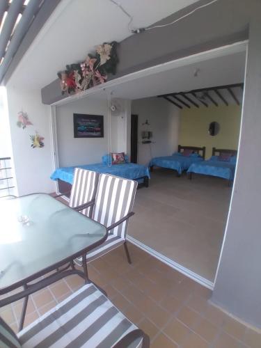 a living room with a table and two beds at Apartasol Santa Fe Oficial in Santa Fe de Antioquia