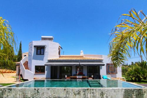 a house with a swimming pool in front of it at Beautiful Algarve Pool Villa Bali 15min to beach in Mexilhoeira Grande