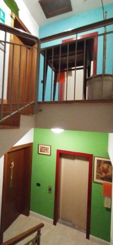 a room with a green wall and stairs with a door at Hotel Milano San Giovanni Lupatoto in San Giovanni Lupatoto