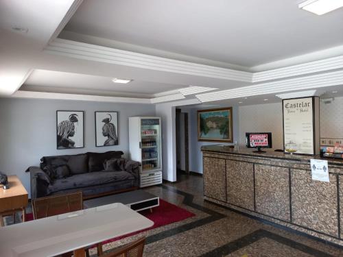 a waiting room with a couch and a counter at Castelar Novo Hotel in Varginha
