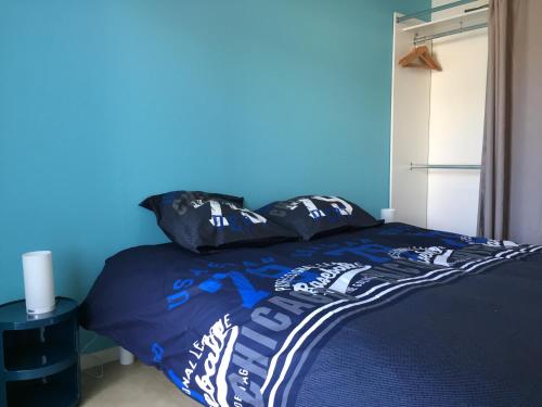 洛里昂的住宿－Magnifique T3 en plein coeur de Lorient, dernier étage avec balcon terrasse，一间卧室配有一张蓝色墙壁的床