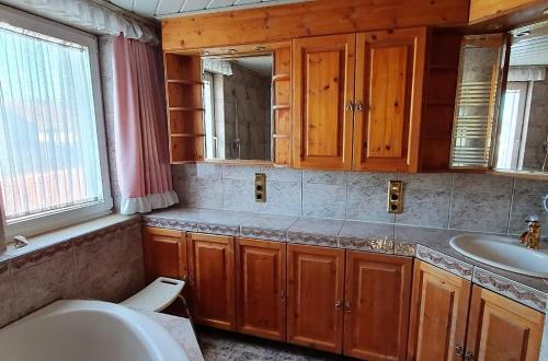 uma casa de banho com uma banheira, um lavatório e um espelho. em Ferienwohnung Ott Schongau em Schongau
