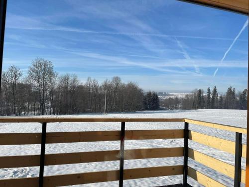 a view of a snow covered field from a fence at Góralski Domek Tomek in Ciche