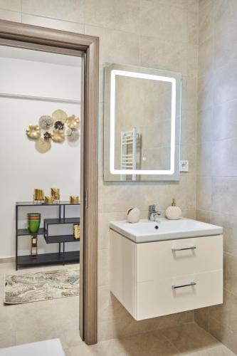 a bathroom with a white sink and a mirror at Unique Hotel Apartments Iasi in Iaşi