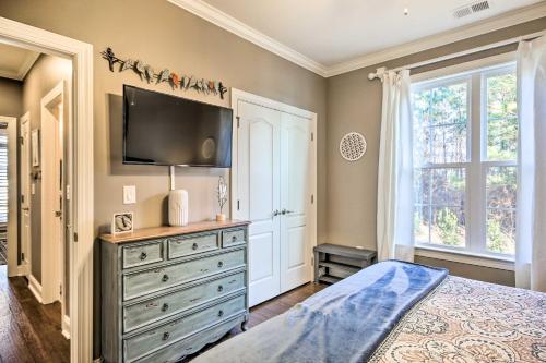 a bedroom with a dresser with a tv on the wall at Elegant Lakefront Gem with Dock and Sunset Views! in Cross Hill