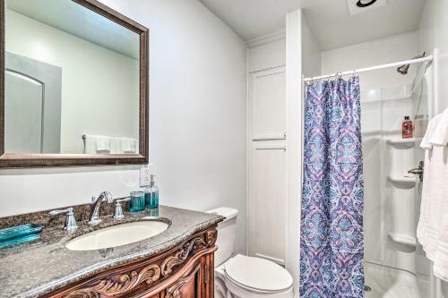 a bathroom with a sink and a toilet and a mirror at Spacious Apt Overlooking AR River Near Dtwn! in Russellville