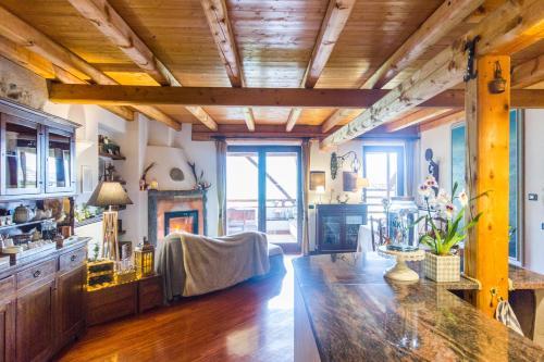 a living room with wooden ceilings and a fireplace at Maso Azzurro Chalet in Stenico