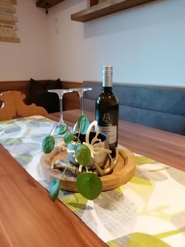 a bottle of wine and two glasses on a table at Apart Julia in Grins