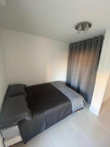 um quarto com uma cama com um cobertor preto em Frejus Plage Acapulco em Fréjus