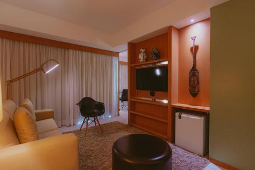 a living room filled with furniture and a tv at Verdegreen Hotel in João Pessoa