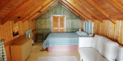 a bedroom with a bed in a wooden cabin at Ocean View Cottage in Arco da Calheta