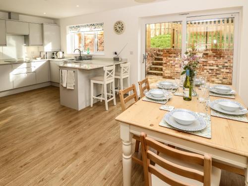 a kitchen and dining room with a table and chairs at Larch Lodge in Totland