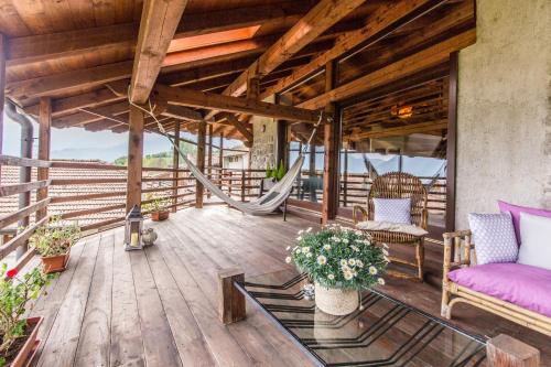 a porch with a hammock and chairs on a deck at Maso Azzurro Chalet in Stenico