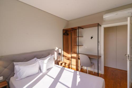 - une chambre avec un lit et une chaise dans l'établissement N Apartments - Bolhão, à Porto