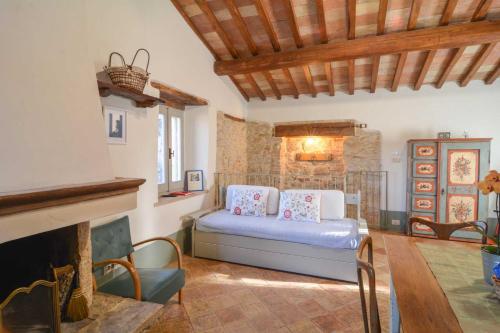 1 dormitorio con 1 cama y chimenea en La casina del vicolo, en Collelungo