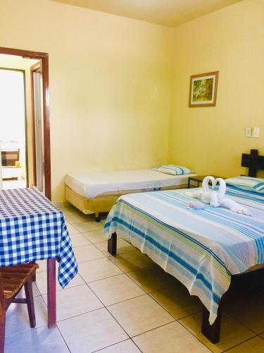 a bedroom with two beds with white towels on them at Calumar Guest House in Ubatuba