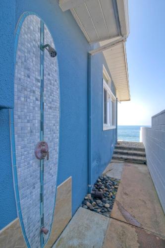 a blue building with a surfboard on the side of it at Oceanfront Villa with Private Beach Access, Remodeled Kitchen in Carlsbad