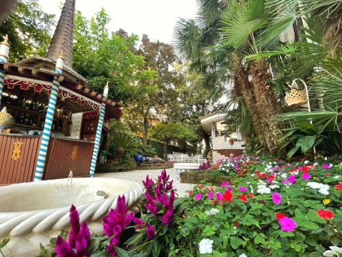 a garden with flowers in front of a building at Milton Boutique Hotel - Adults Only in Lido di Jesolo