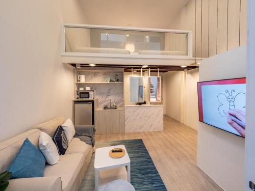 een woonkamer met een bank en een flatscreen-tv bij Ease Me Residence in Hat Yai