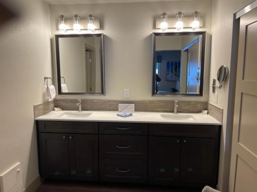a bathroom with two sinks and two mirrors at Tahoe Trail Resort in Stateline